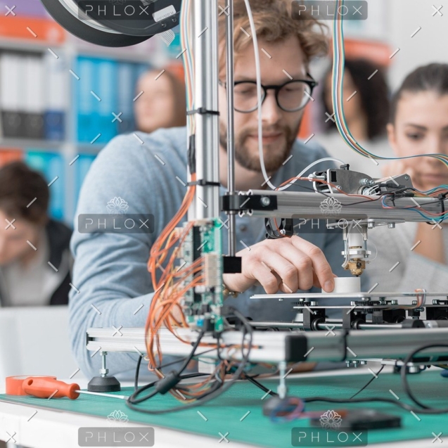 demo-attachment-118-students-using-a-3d-printer-PJKMSXD