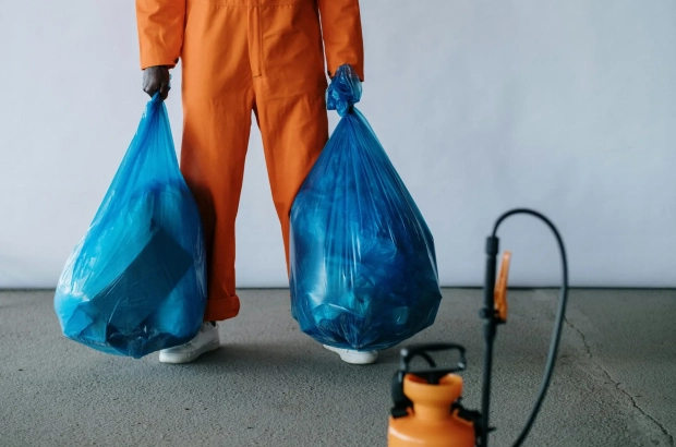 Photo by cottonbro studio: https://www.pexels.com/photo/man-in-orange-overalls-holding-blue-bags-9222613/